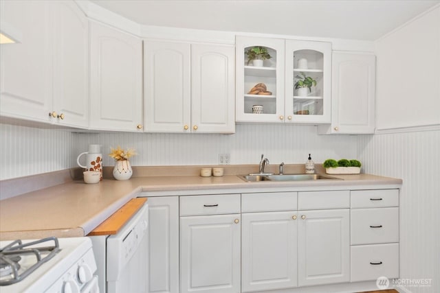 kitchen featuring a sink, white cabinetry, glass insert cabinets, and light countertops