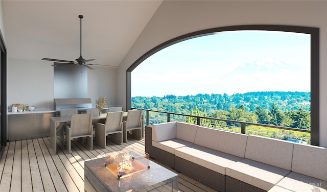 balcony featuring area for grilling, outdoor lounge area, a ceiling fan, and a wooded view