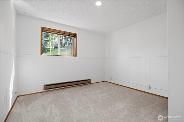 3785 Greenville Pl, Bellingham, WA 98226 - empty room featuring a baseboard radiator, a textured ceiling, carpet, wainscoting, and baseboards