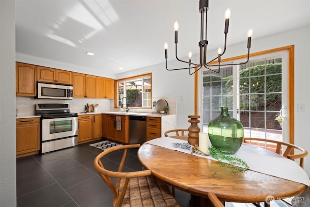 3785 Greenville Pl, Bellingham, WA 98226 - kitchen featuring stainless steel appliances, a chandelier, backsplash, dark tile patterned floors, and light countertops