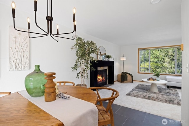3785 Greenville Pl, Bellingham, WA 98226 - carpeted dining space with a chandelier, a warm lit fireplace, and tile patterned floors