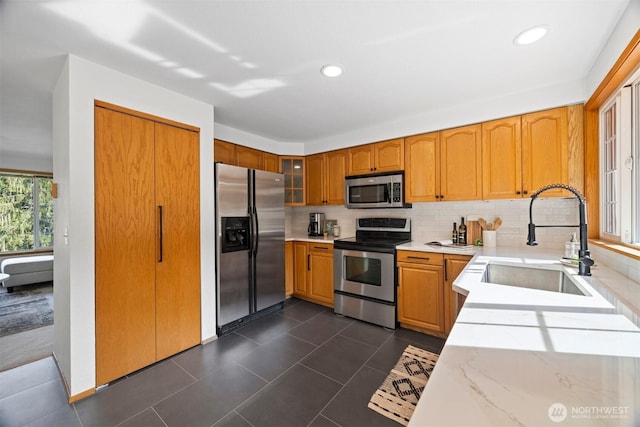 3785 Greenville Pl, Bellingham, WA 98226 - kitchen featuring appliances with stainless steel finishes, a sink, tasteful backsplash, glass insert cabinets, and dark tile patterned flooring
