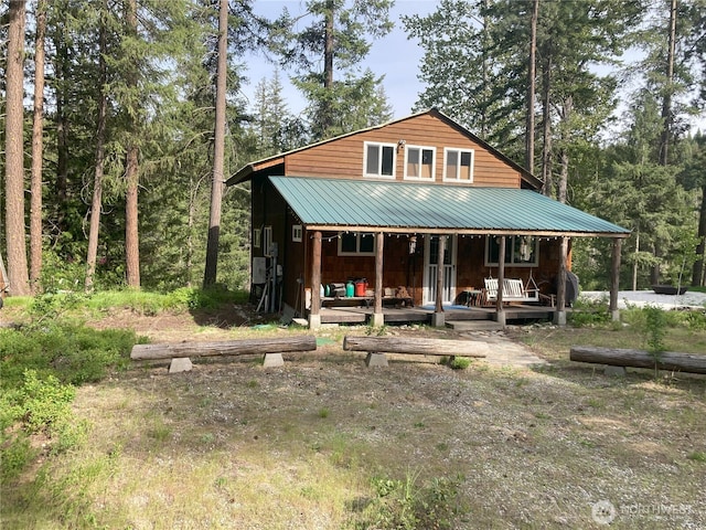 chalet / cabin featuring covered porch and metal roof