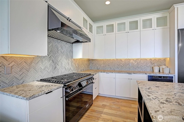 kitchen with light stone countertops, under cabinet range hood, gas stove, dishwashing machine, and decorative backsplash