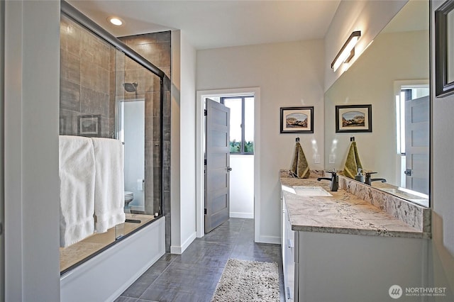 full bathroom with a tile shower, vanity, toilet, recessed lighting, and baseboards