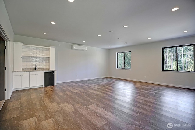 unfurnished living room featuring dark wood-style flooring, recessed lighting, a wall unit AC, and wet bar
