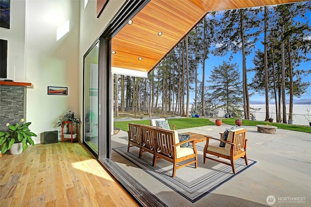 interior space featuring fence, a water view, and a fire pit