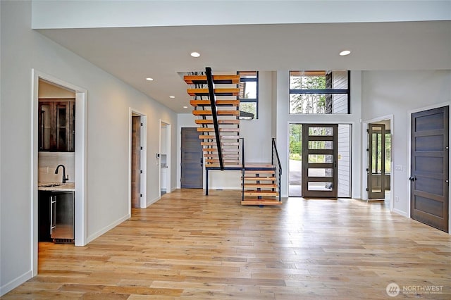 1699 SE Camano Dr, Camano Island, WA 98282 - entrance foyer featuring stairway, light wood finished floors, recessed lighting, a towering ceiling, and bar