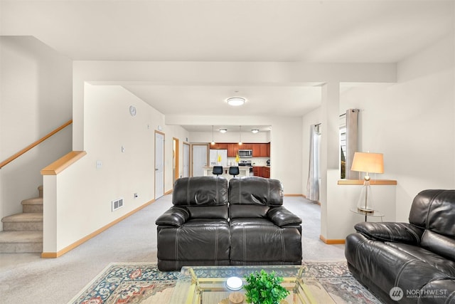 343 Tremont Ave Unit 102, Bellingham, WA 98226 - living room featuring light carpet, stairs, baseboards, and visible vents