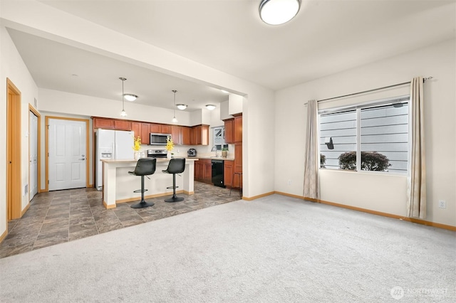 343 Tremont Ave Unit 102, Bellingham, WA 98226 - kitchen featuring light carpet, a kitchen bar, light countertops, baseboards, and appliances with stainless steel finishes