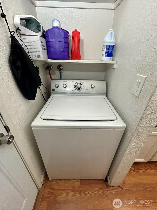 washroom featuring washer / clothes dryer, a textured wall, and baseboards