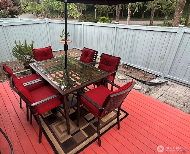 deck with outdoor dining area and a fenced backyard