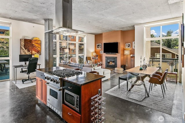 125 E Lynn St Unit 205, Seattle, WA 98102 - kitchen with stainless steel appliances, island range hood, a desk, and concrete floors