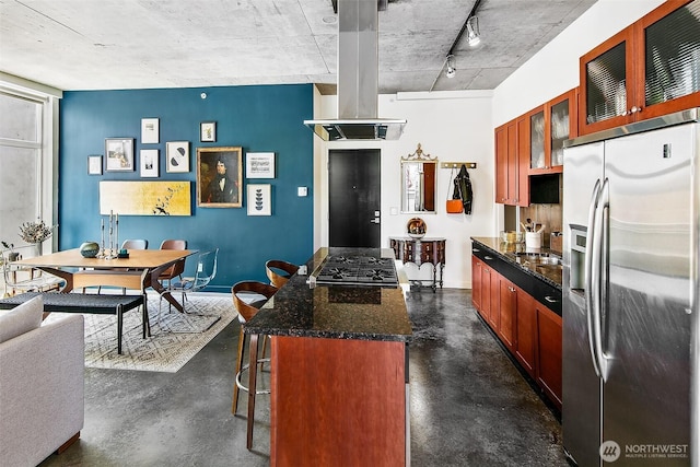 125 E Lynn St Unit 205, Seattle, WA 98102 - kitchen with appliances with stainless steel finishes, rail lighting, finished concrete flooring, a kitchen breakfast bar, and glass insert cabinets