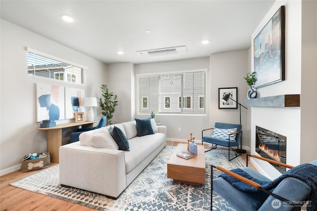 living room featuring recessed lighting, baseboards, and wood finished floors