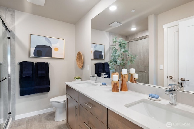 bathroom with a sink, double vanity, toilet, and a stall shower