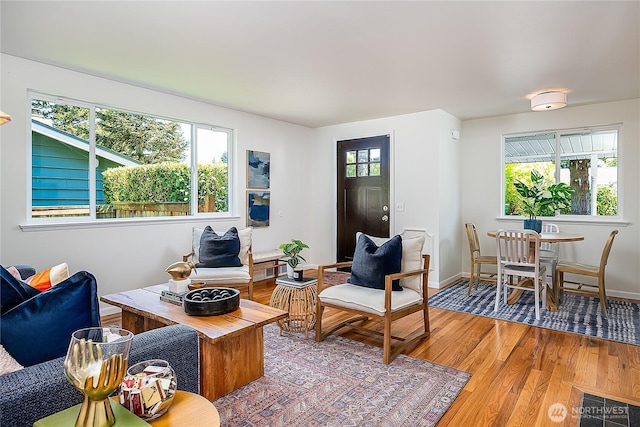 living area with light wood-type flooring and baseboards