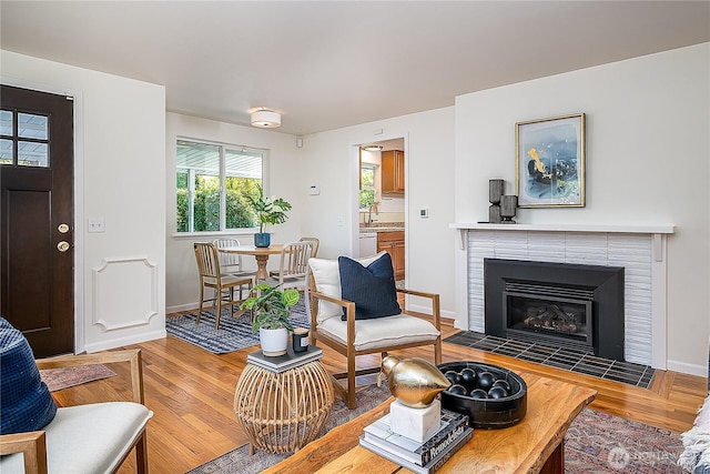living area featuring wood finished floors, a fireplace, and baseboards