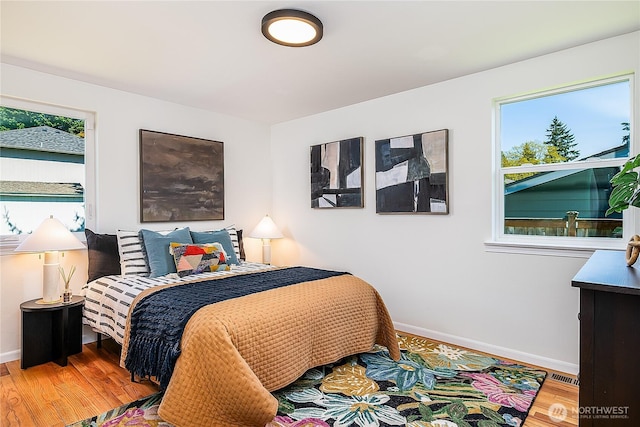 bedroom with wood finished floors and baseboards
