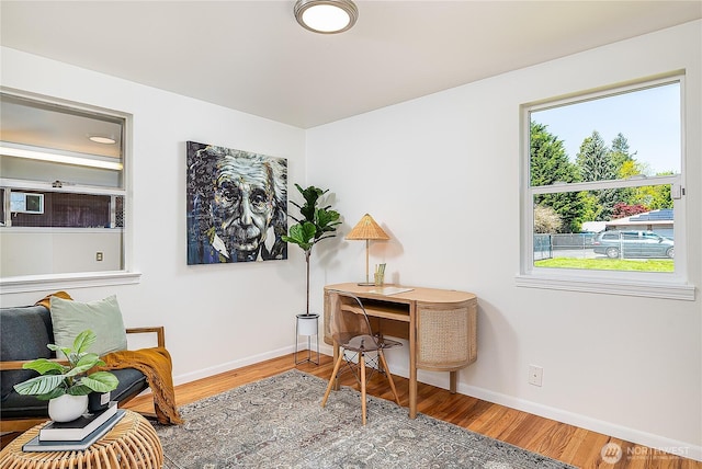 office area with baseboards and wood finished floors