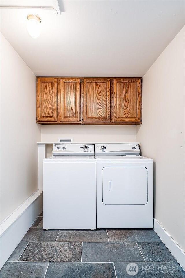 washroom featuring cabinet space, independent washer and dryer, and baseboards