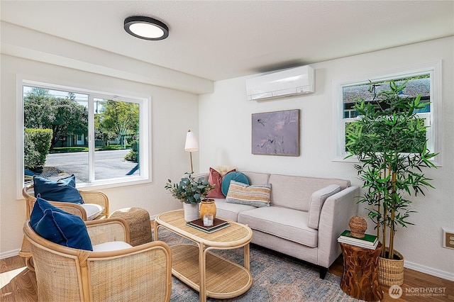 living area featuring a wall unit AC, wood finished floors, and baseboards