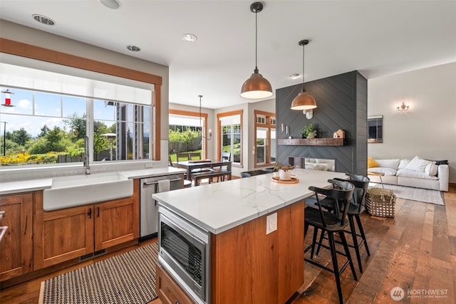 14028 104th Street Ct E, Puyallup, WA 98374 - kitchen featuring a sink, appliances with stainless steel finishes, dark wood-type flooring, a breakfast bar area, and brown cabinetry