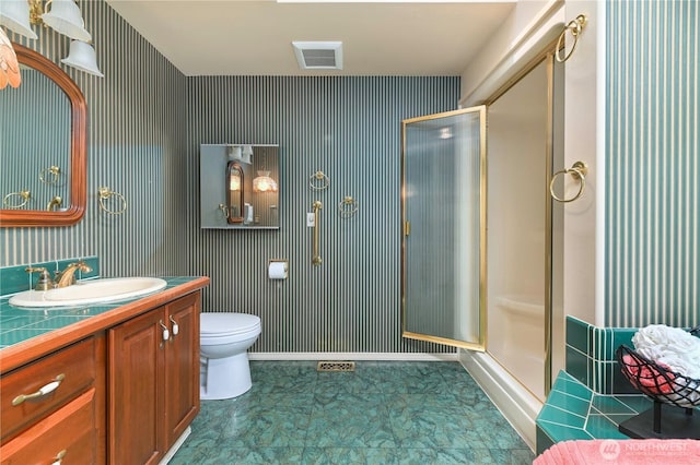 bathroom with a shower stall, vanity, toilet, and baseboards