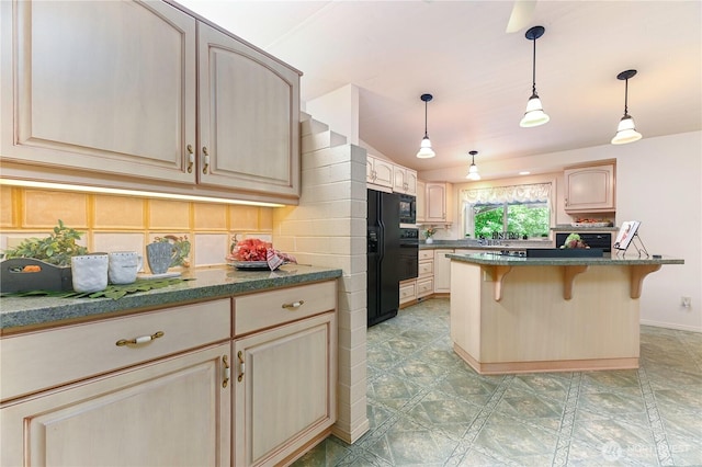kitchen with black appliances, a kitchen bar, hanging light fixtures, and a kitchen island