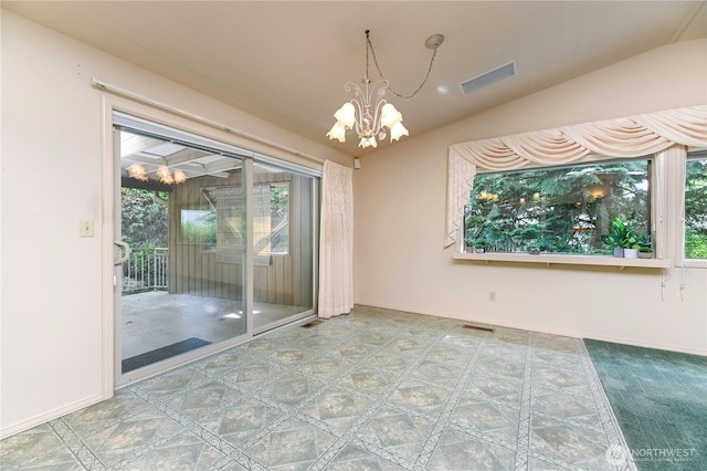 spare room featuring a chandelier, healthy amount of natural light, and lofted ceiling