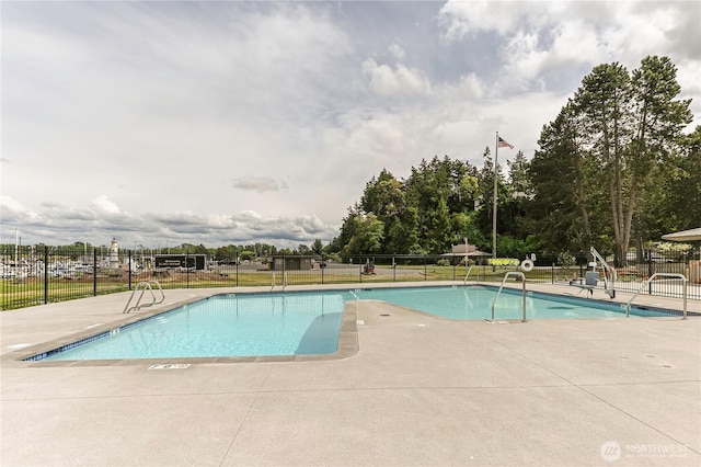 community pool featuring fence and a patio