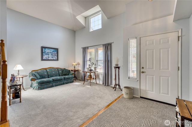 carpeted foyer with a high ceiling and baseboards
