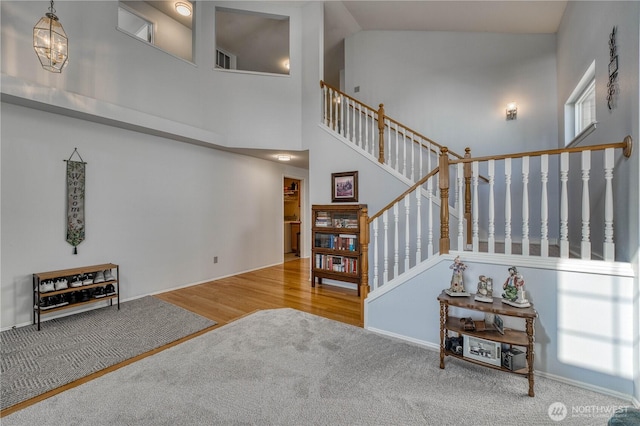 stairway with a high ceiling and wood finished floors