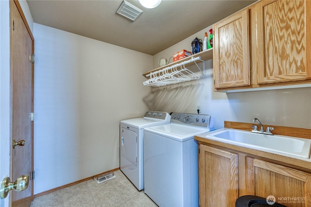 washroom with washing machine and dryer, cabinet space, and baseboards