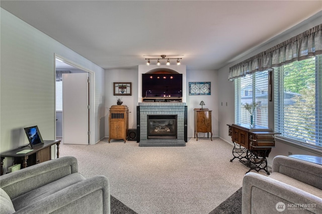living room with healthy amount of natural light, light carpet, a fireplace, and baseboards