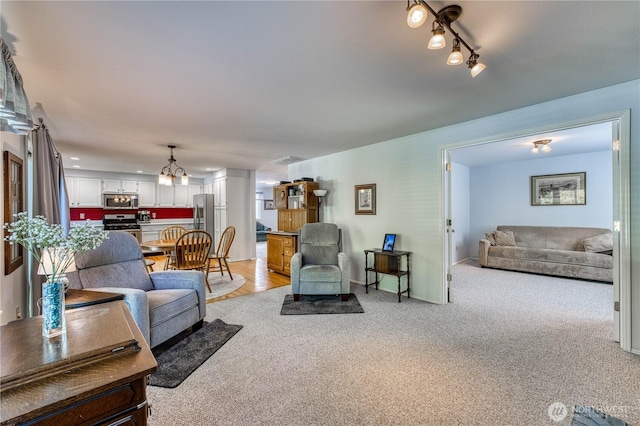 living room with a chandelier and light colored carpet