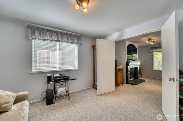 interior space with carpet flooring, a tile fireplace, and baseboards