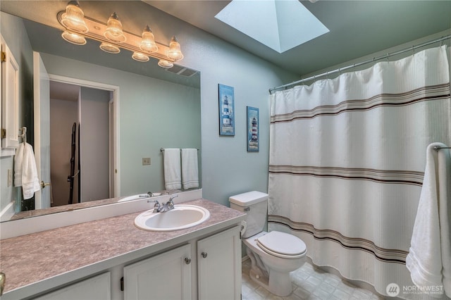 bathroom featuring a skylight, vanity, and toilet