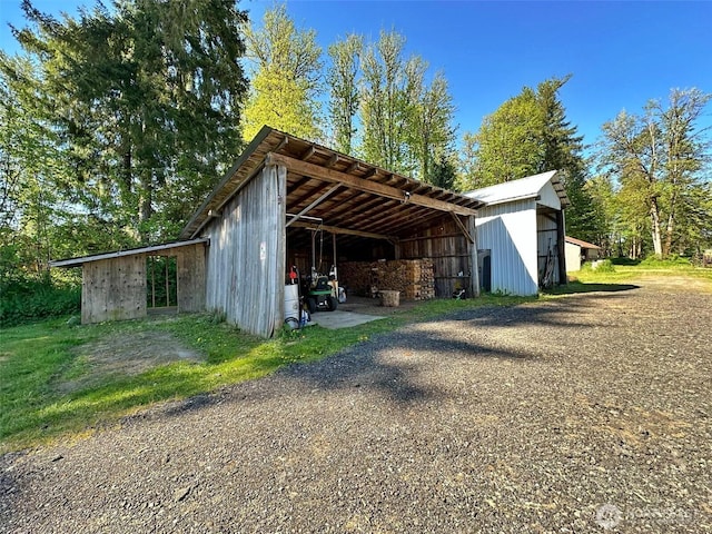 view of pole building with a carport and driveway