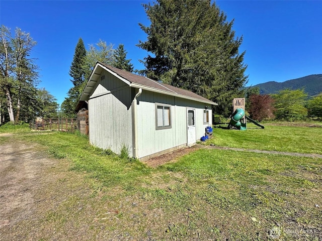 view of outdoor structure with an outdoor structure, a playground, and a mountain view