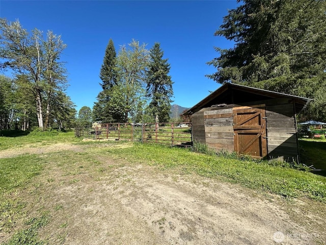 view of yard featuring fence and an outbuilding