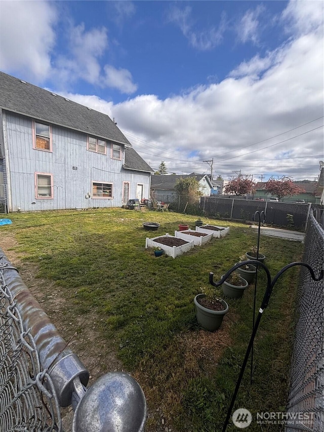 view of yard with a fenced backyard and a vegetable garden