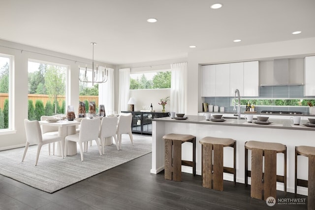 24211 118th Pl SE, Kent, WA 98030 - kitchen with a breakfast bar, a sink, wall chimney exhaust hood, modern cabinets, and white cabinetry