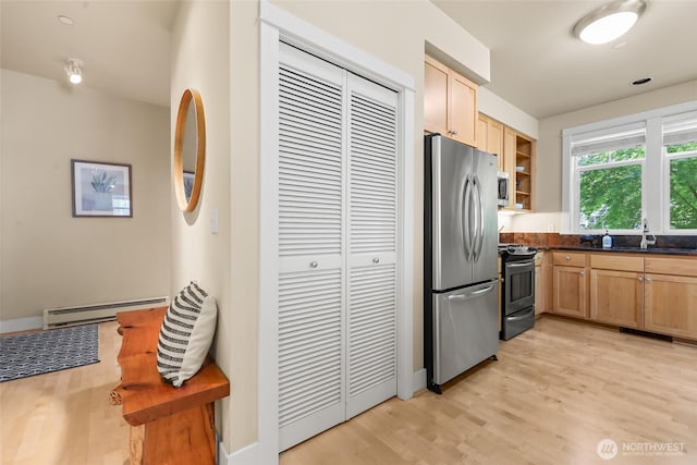 kitchen featuring stainless steel appliances, baseboard heating, light wood-style floors, dark countertops, and light brown cabinetry