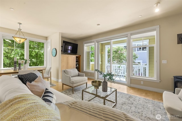 living room with baseboards, a wood stove, and recessed lighting