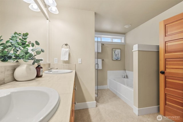 bathroom featuring a bath, baseboards, and double vanity