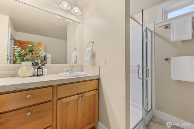 bathroom featuring a stall shower, vanity, and baseboards
