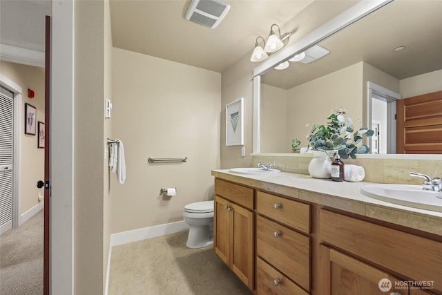 full bathroom featuring toilet, baseboards, and double vanity