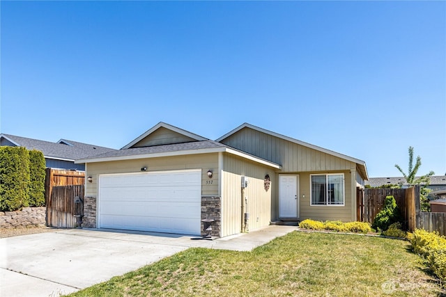 557 N Montclair Ave N, East Wenatchee, WA 98802 - ranch-style home with fence, stone siding, driveway, a garage, and a front lawn