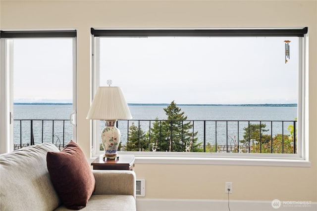 sitting room with a water view and baseboards